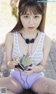 A young woman sitting on the ground holding a cassette player.