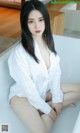 A woman sitting on top of a white bathtub.