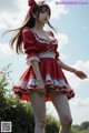 A woman in a red and white dress is posing for a picture.