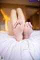 A close up of a person's feet on a bed.