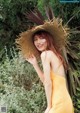 A woman in a yellow dress and a straw hat.