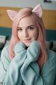 A woman with pink hair wearing a cat ears headband.