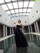 A woman in a black dress standing in a pool.