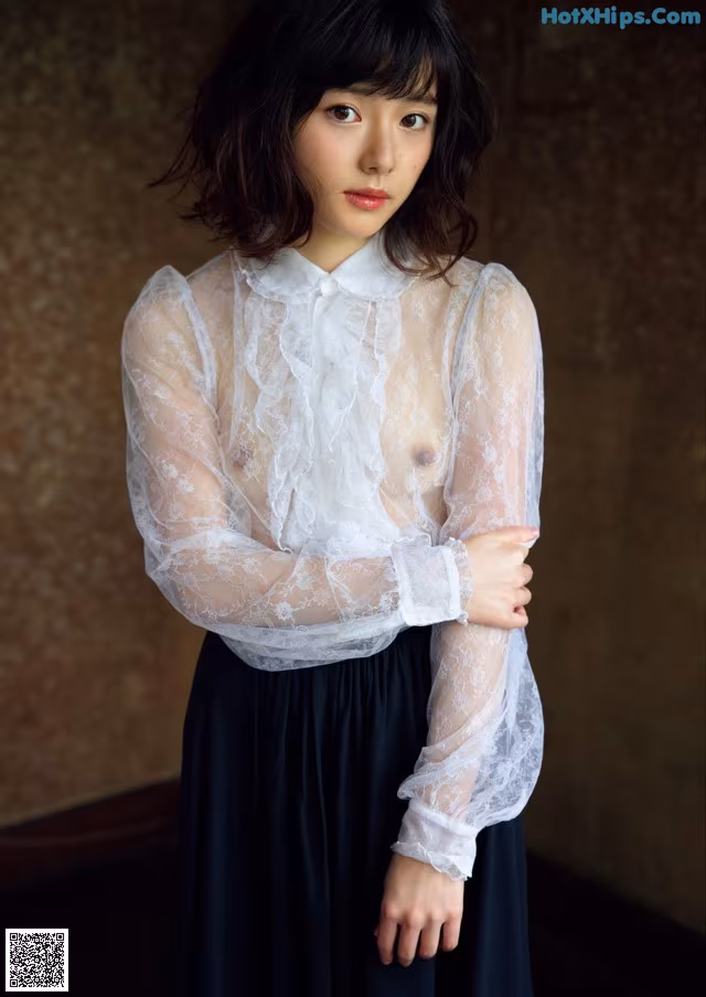 A woman wearing a white blouse and black skirt.